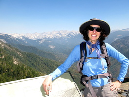Lori atop Moro Rock with the Great Western Divide and Kaweah Peaks Ridge cutting the horizon behind her