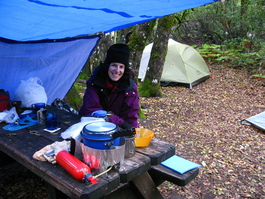 Lori waits for dinner at our campsite
                            (hint: it's not chicken, risotto, or
                            stew)