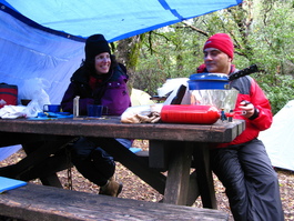 Lori and Carlos enjoy conversation while
                       campmate Dave sleeps