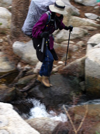Lori crosses the creek to camp gingerly