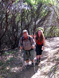 Dave and Carrie hike through the large
                            manzanita bushes