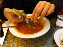 A clever scissors is used to shred basil into the fresh (and delicious!) tomato soup