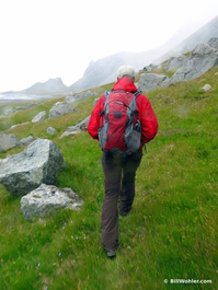 Gunnar hikes across a boggy meadow