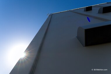The sun peeks behind the tower
