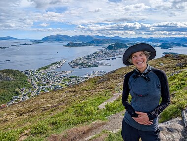 Lori on top of Sukkertoppen with &Aring;lesund down below