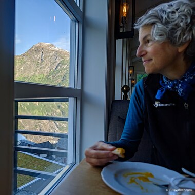 Lori takes in the stunning view of the mountains mirrored in the still waters of the iconic Geirangerfjord.